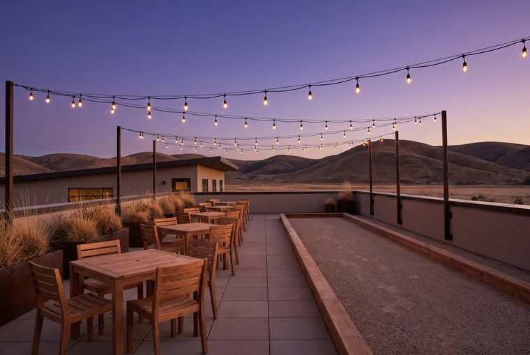 Illustration: a rooftop patio at dusk with wooden tables, a gravel bocce court along one side and strings of warm lights overhead.